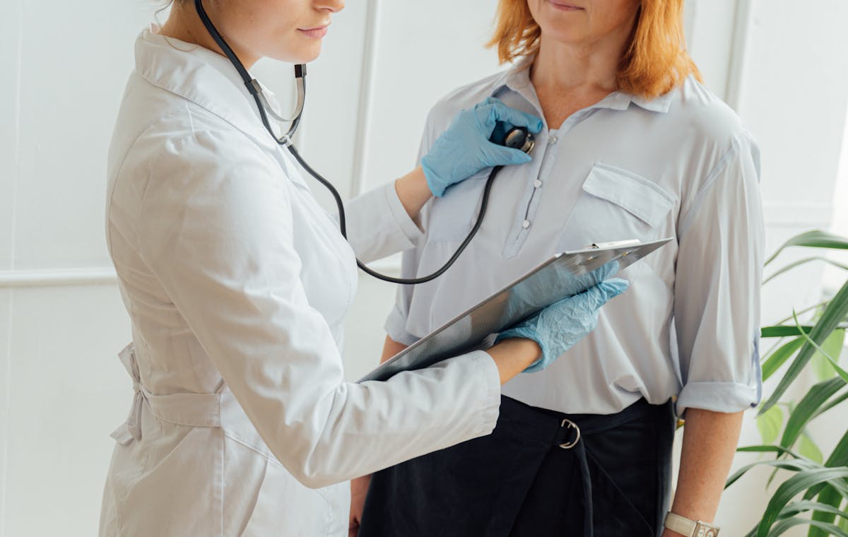 Médica avaliando paciente em consulta cardiovascular com estetoscópio